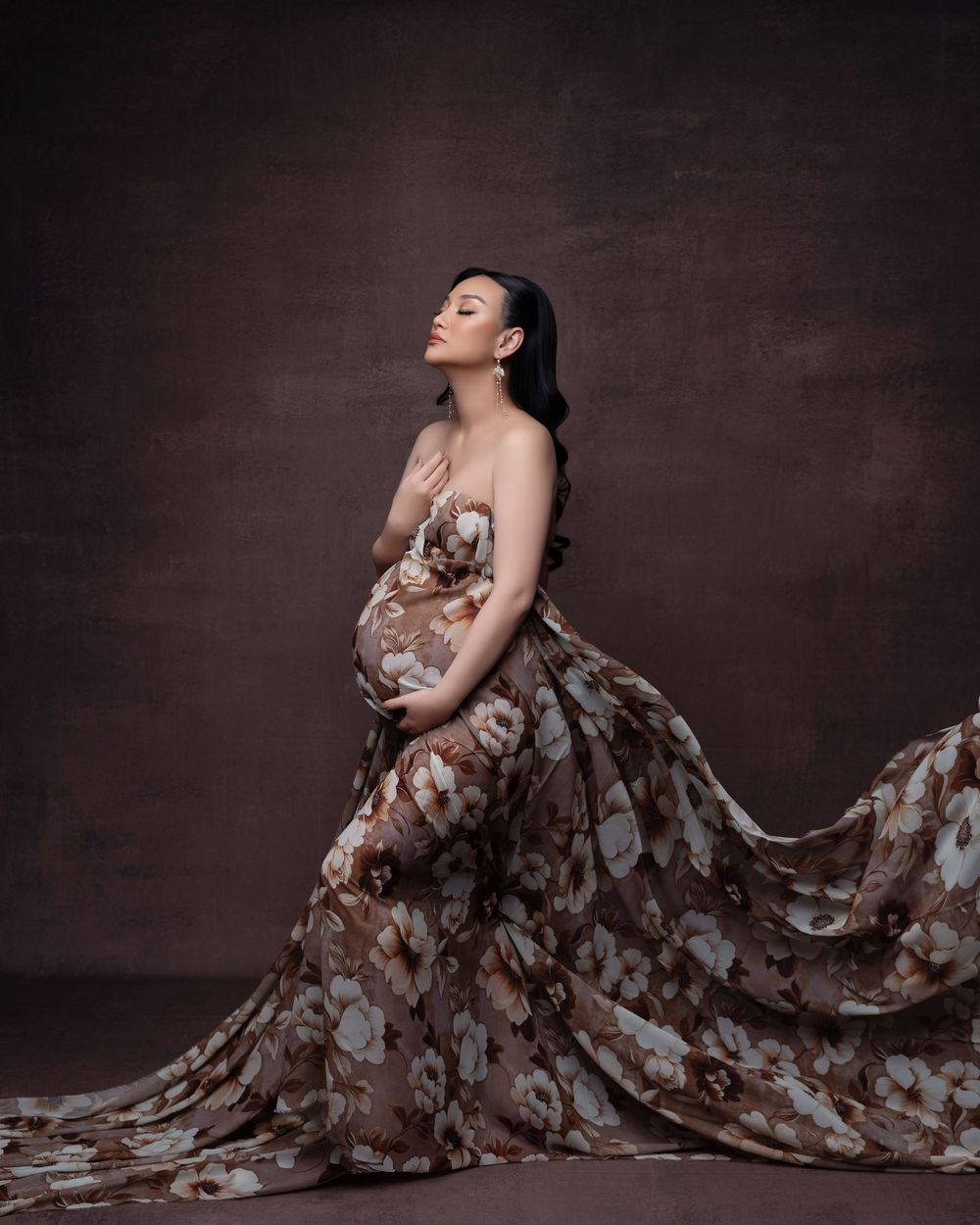 Dramatic portrait series featuring model in brown floral gown posed against dark studio backdrop.
