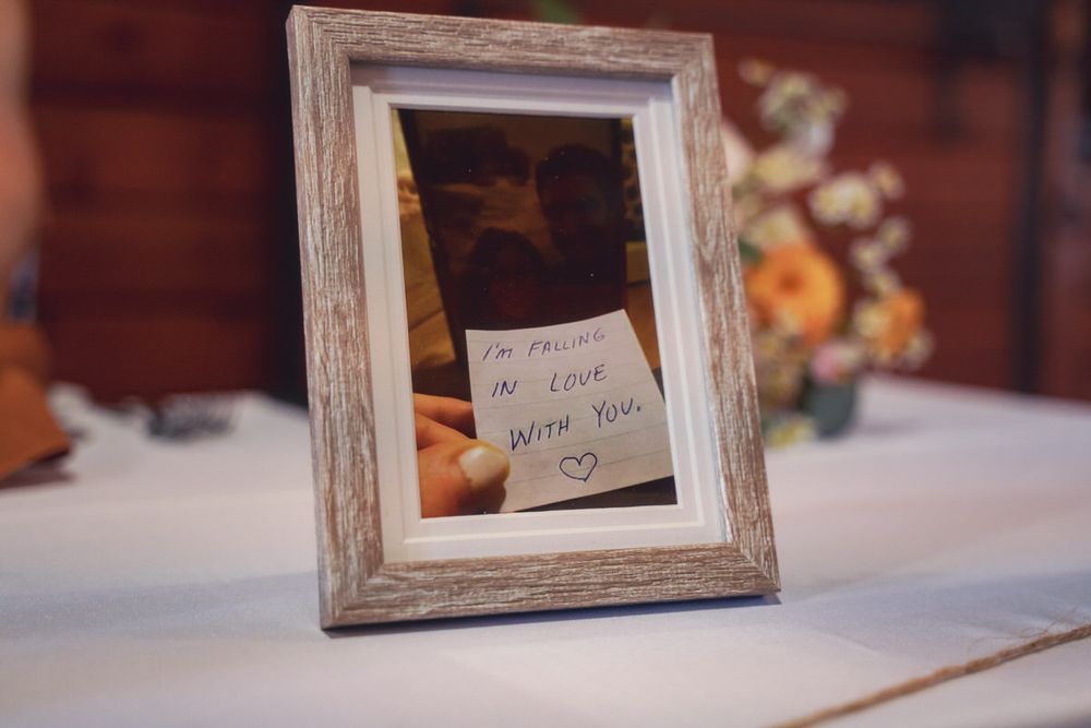 A simple photograph in a wooden frame decorate the head table at this fall DIY wedding reception.