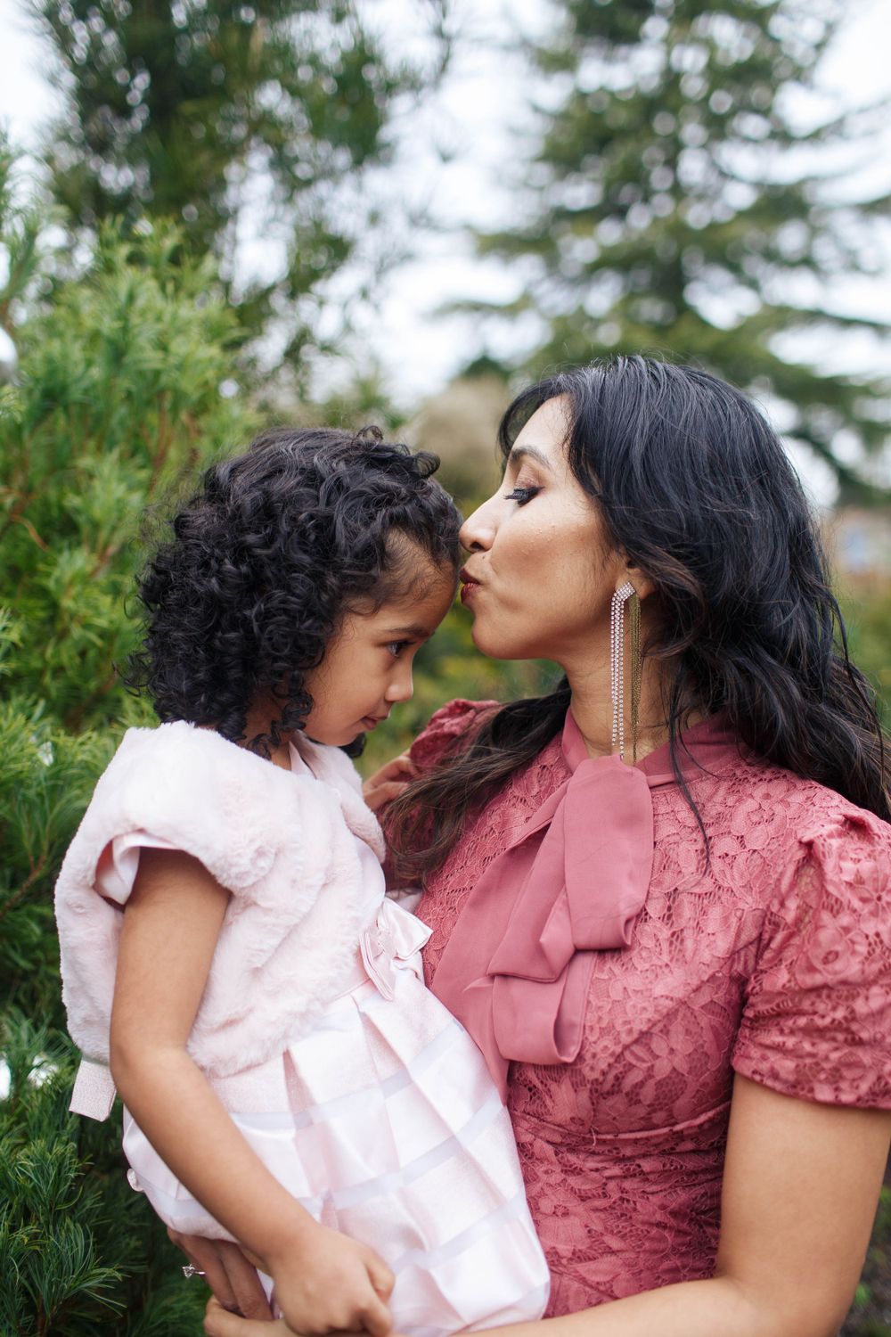 Mom and Me photographer in Seattle: A mother kisses her daughter on the forehead during a family photo session