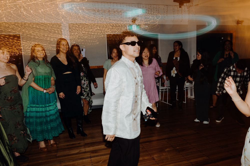 Guests enjoying a lively dance party in a venue decorated with string lights on the ceiling.