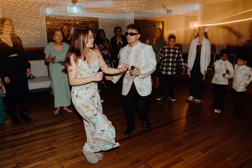 Party guests dancing together on a hardwood floor at a formal event.