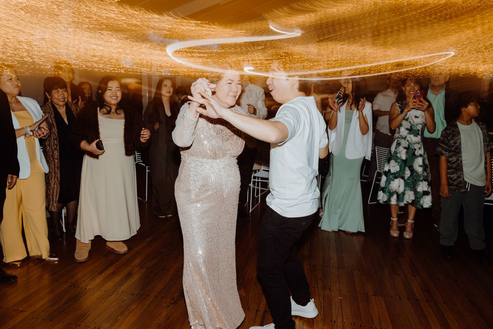 Couples dancing together at a celebration with elegant decor and mood lighting.