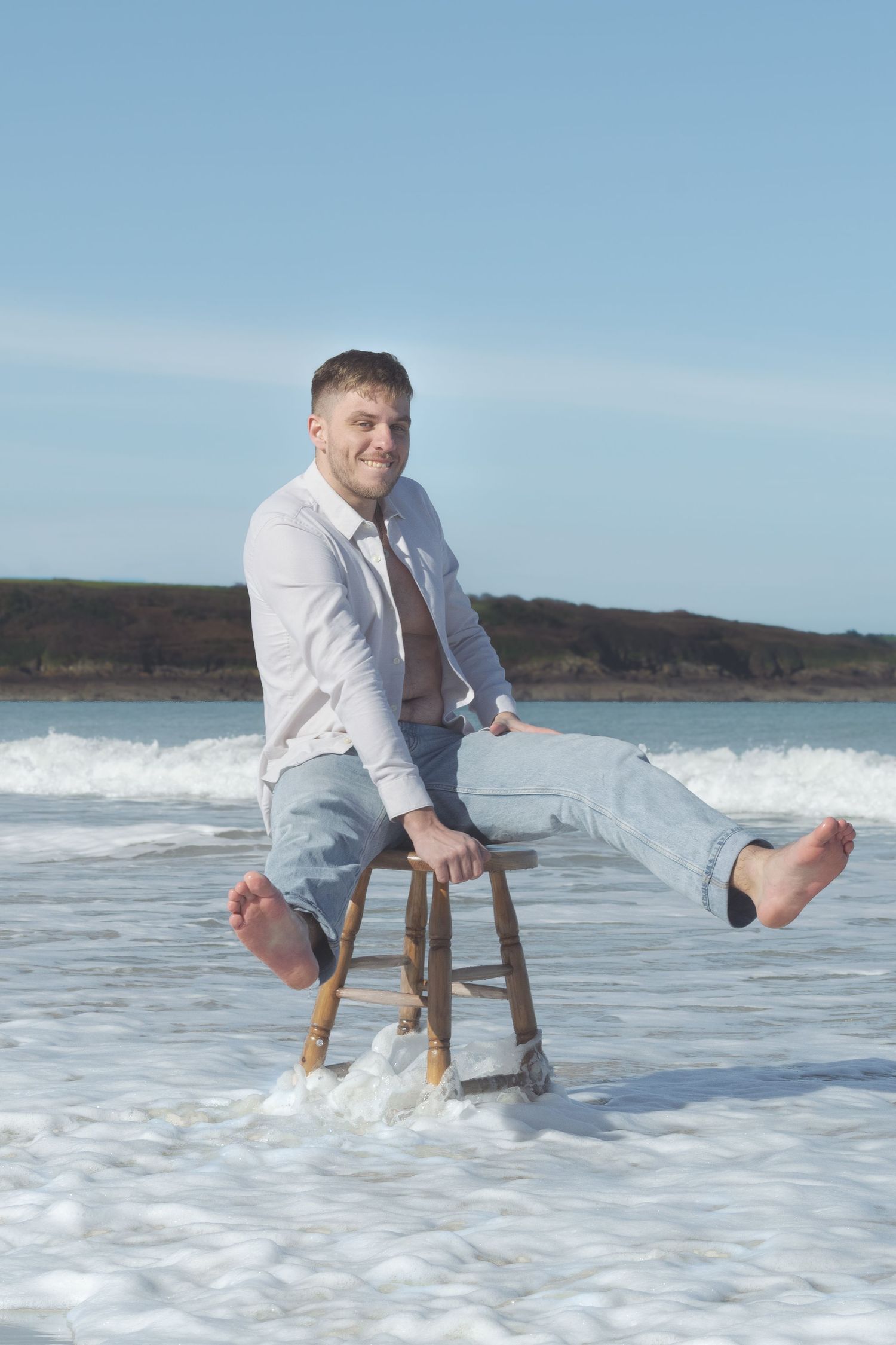 Photographie d'un homme à la mer assis sur un tabouret