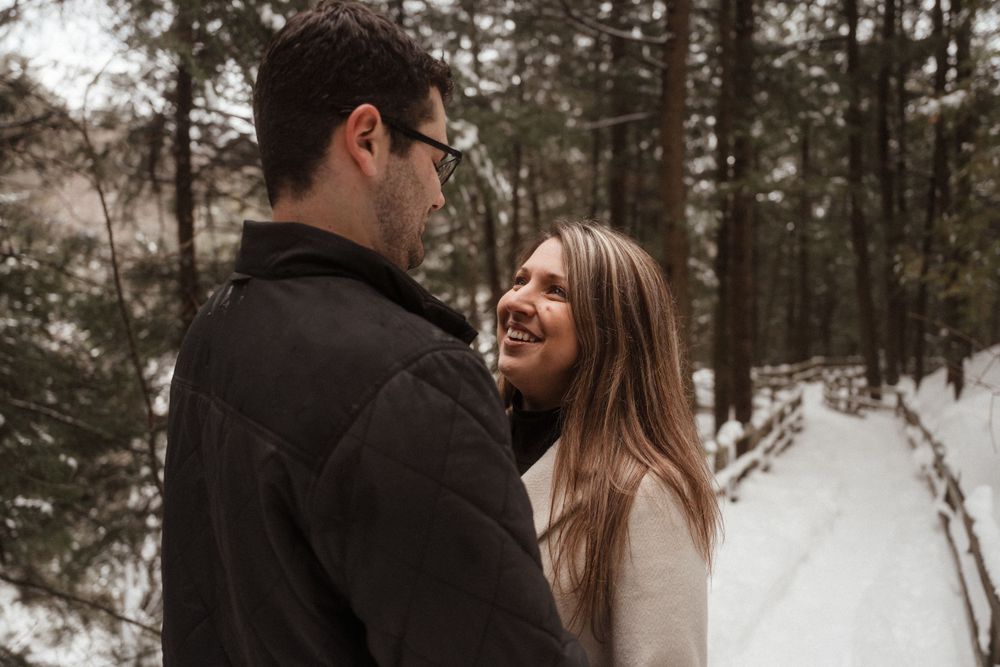 Intimate winter forest portrait of a couple sharing a loving moment.