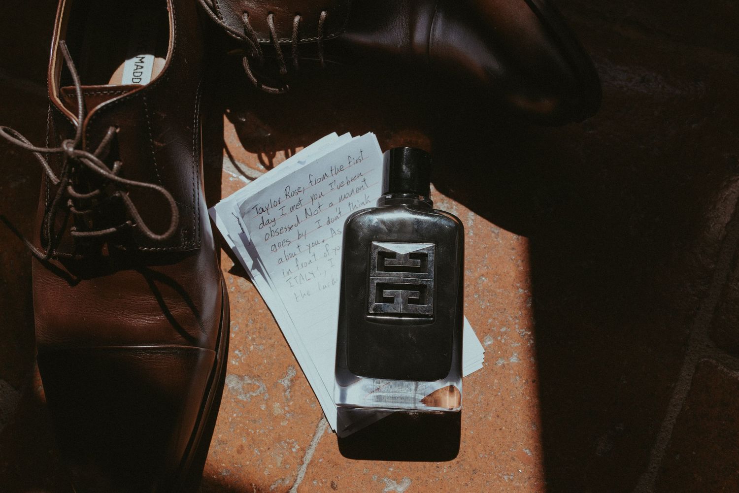 A smartphone and handwritten note on a dark wooden surface in low light.