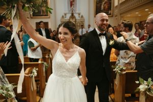Newlyweds celebrate with joy as they exit their church ceremony.