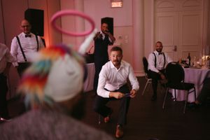 Wedding guests enjoying entertainment and dancing at reception celebration.