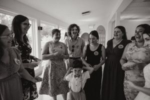 A group of wedding guests gather together for a candid moment at a celebration.