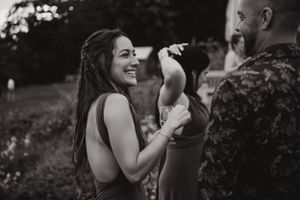 A couple dances and laughs together outdoors during their celebration.