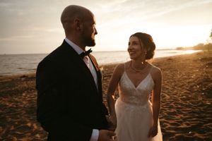 Moment intime au bord de l'eau entre le couple en tenue de mariage pendant l'heure d'or.
