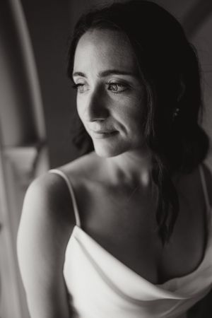 A portrait of a woman in a white dress looking to the side with soft lighting.