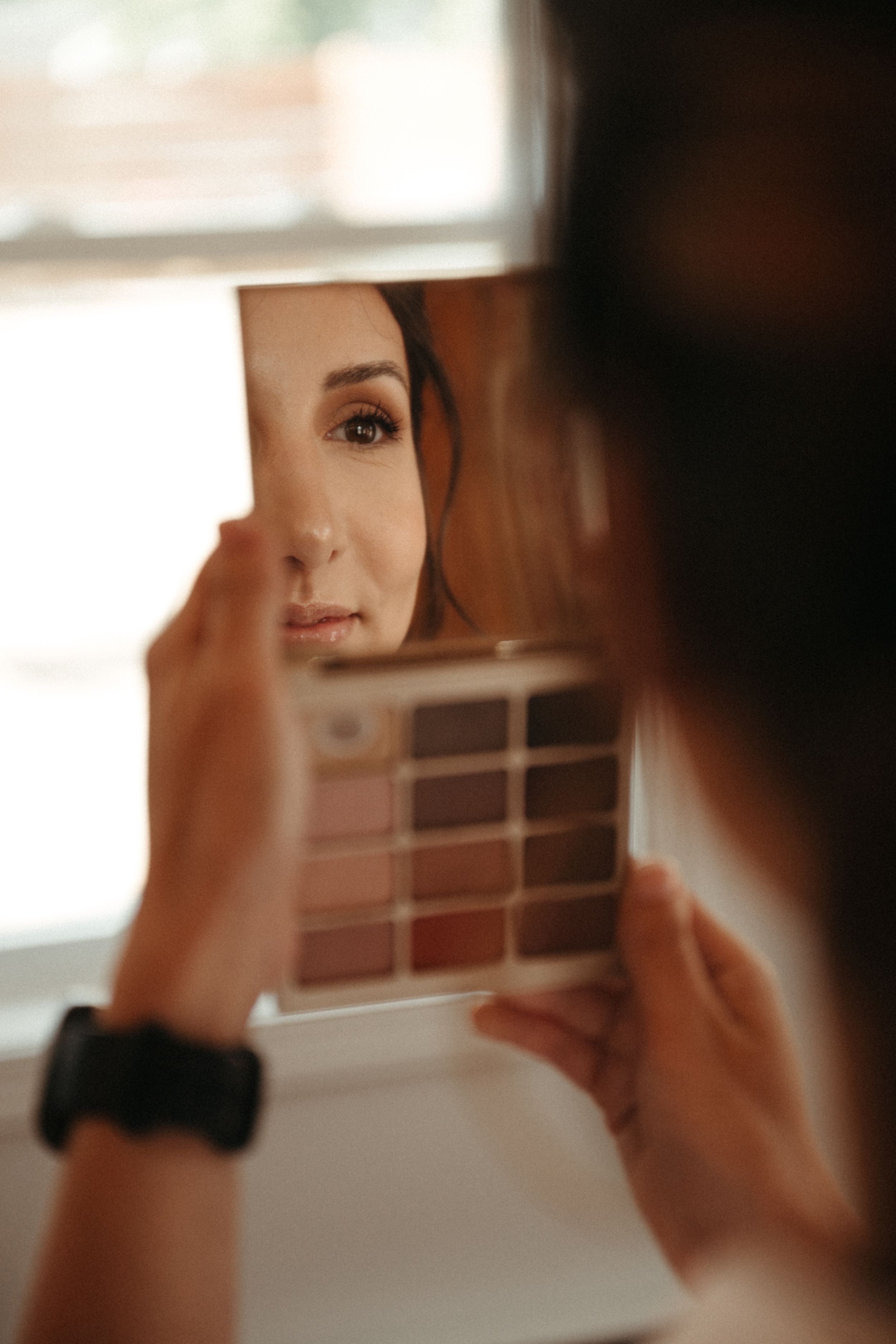 A reflection in a small mirror shows preparation details before a wedding ceremony.