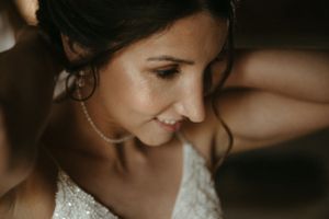 Close-up portrait of a person in a lace wedding dress with soft, romantic lighting.