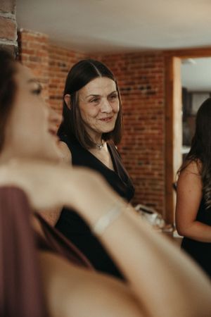 Wedding preparations scene with attendant in black dress.
