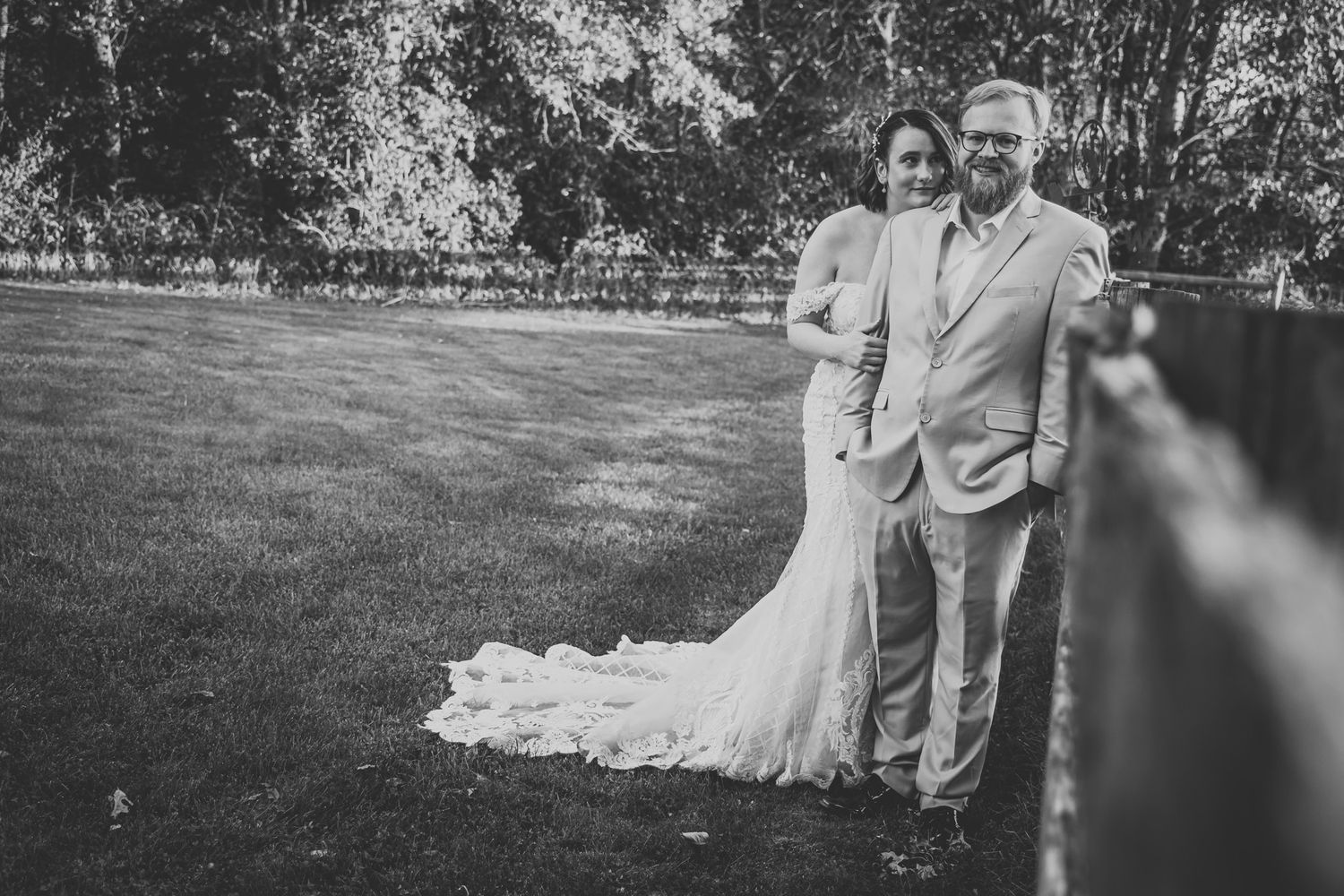 Black and white wedding photo of couple standing together on lawn.
