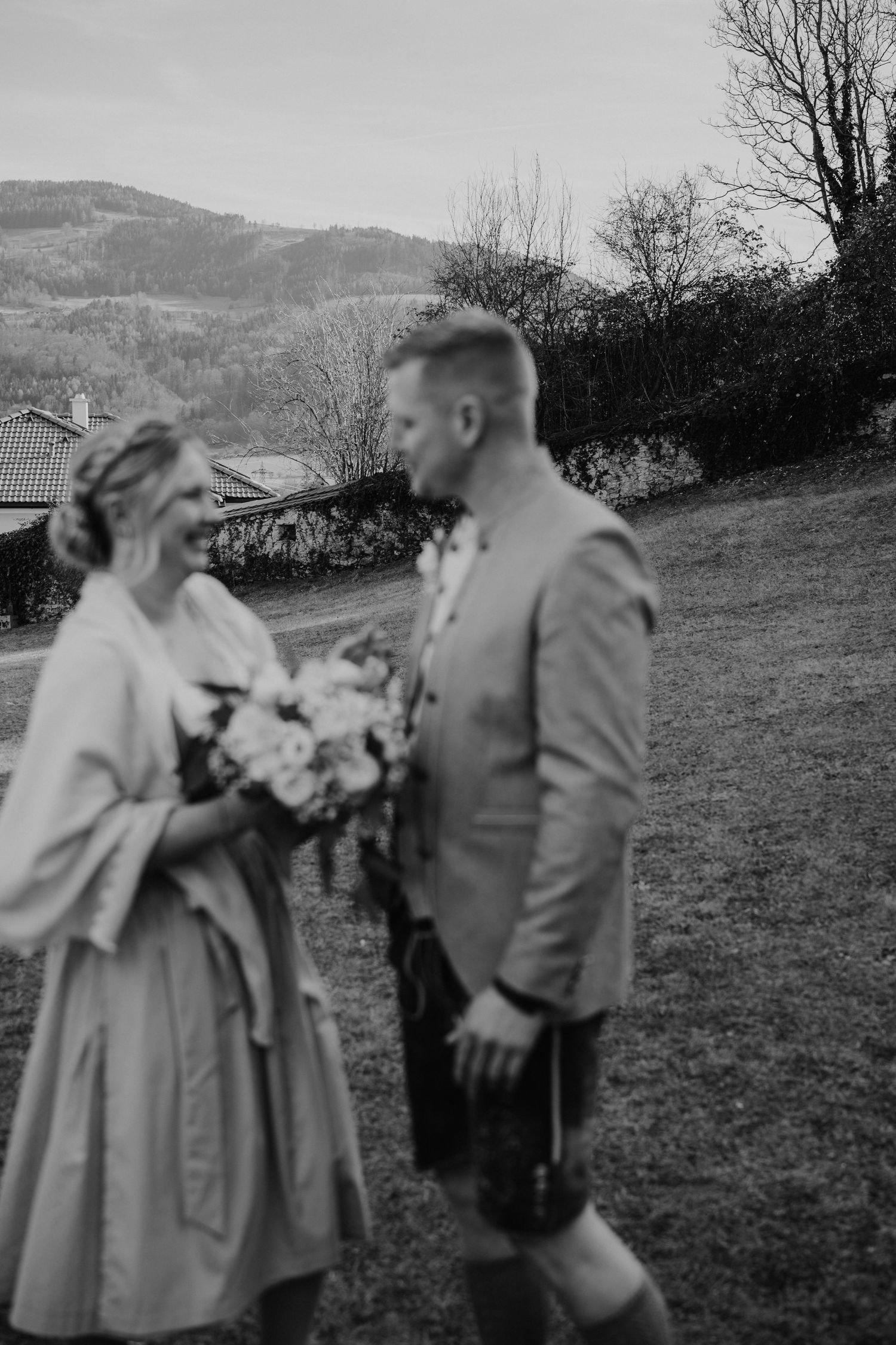 schwarz weiß Foto von einem Brautpaar in Tracht vor einer schönen Bergkulisse