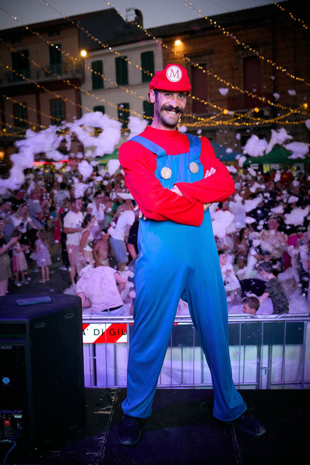 Person dressed in a red and blue video game character costume posing at a festive event.
