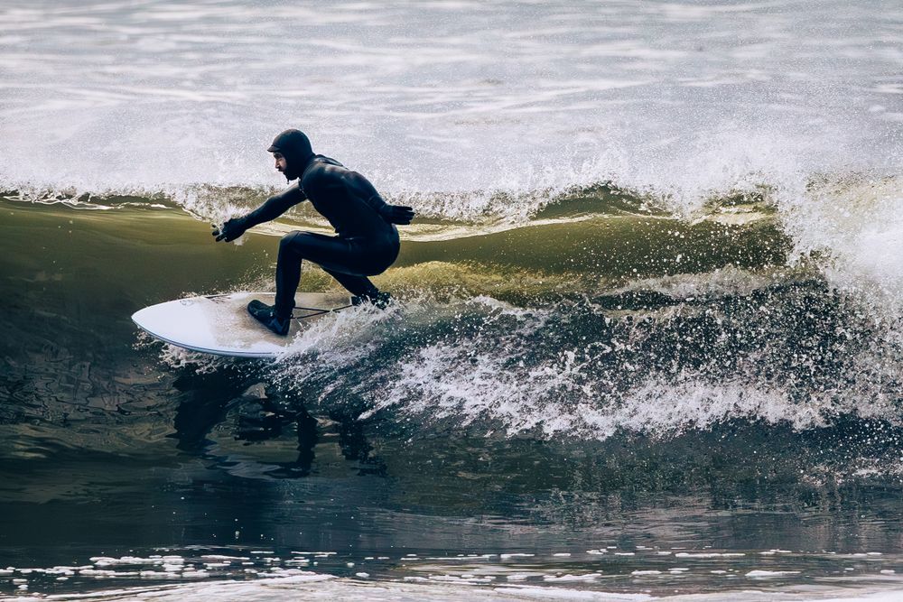 A surfer rides a powerful wave, creating dramatic splashes of water during the ride at Jordan River, Vancouver Island.