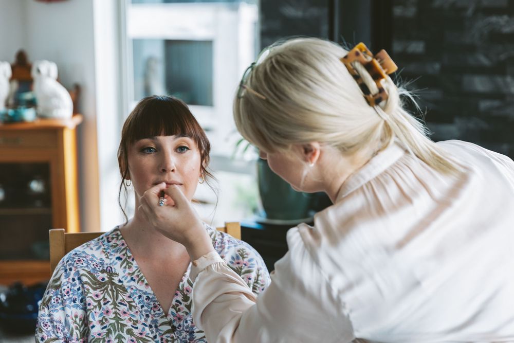 Professional makeup application in progress during wedding preparation.