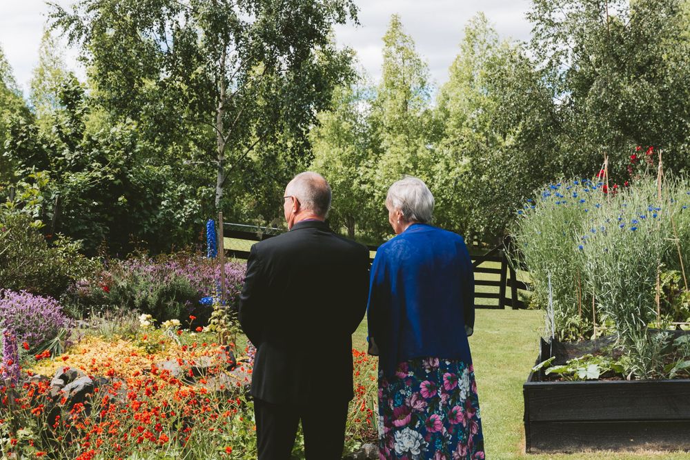 Two people admiring colorful flower garden on a sunny summer day.