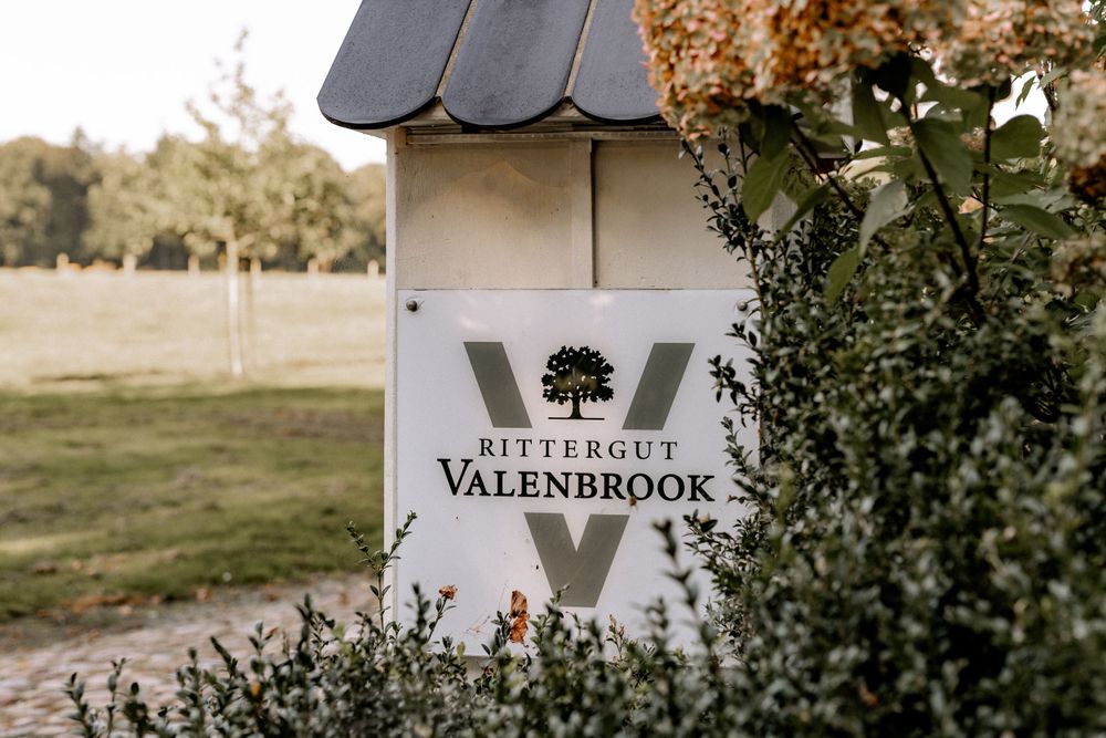 Valenbrook estate entrance sign mounted on a decorative post with landscaping.