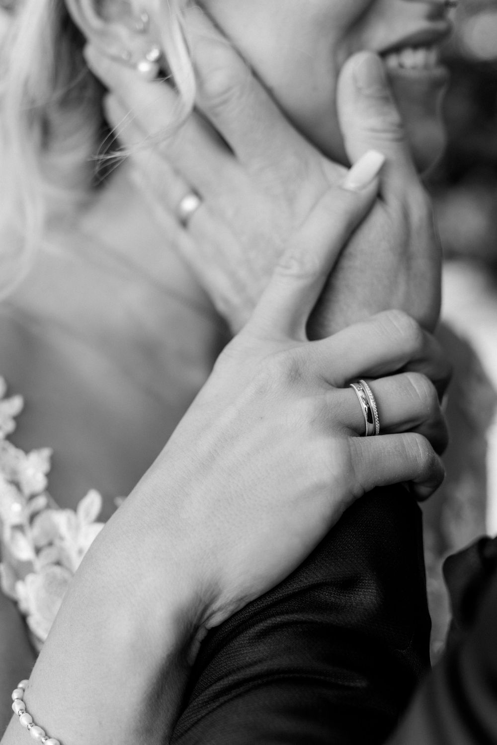 Detail shot of wedding rings and tender touch during intimate moment.