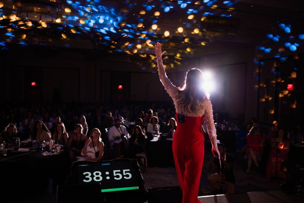Silhouette of performer on stage with colorful bokeh lights and timer display.