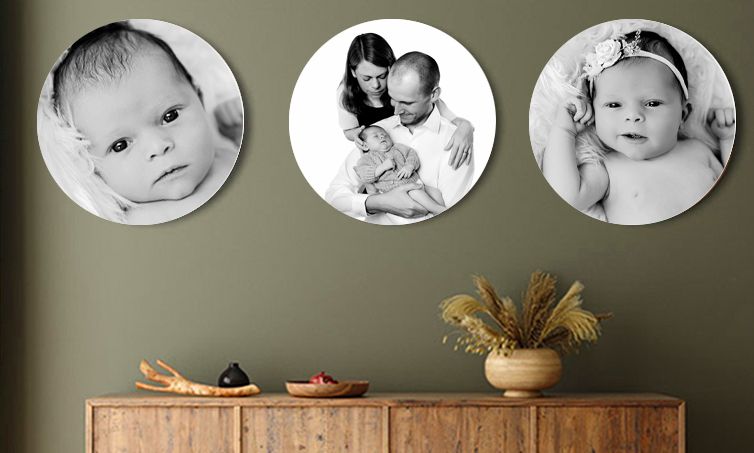 Three circular black and white portrait photographs displayed above a wooden sideboard with a decorative vase arrangement.