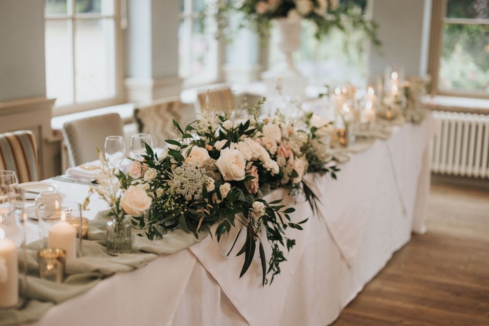 Wedding reception decor featuring blush floral centrepieces and white table settings at Washingborough Hall - taken by Grimsby photographer.