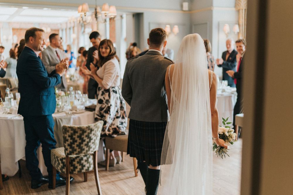 Elegant wedding reception in a bright white venue with crystal chandeliers and guests at Washingborough Hall - taken by Grimsby photographer