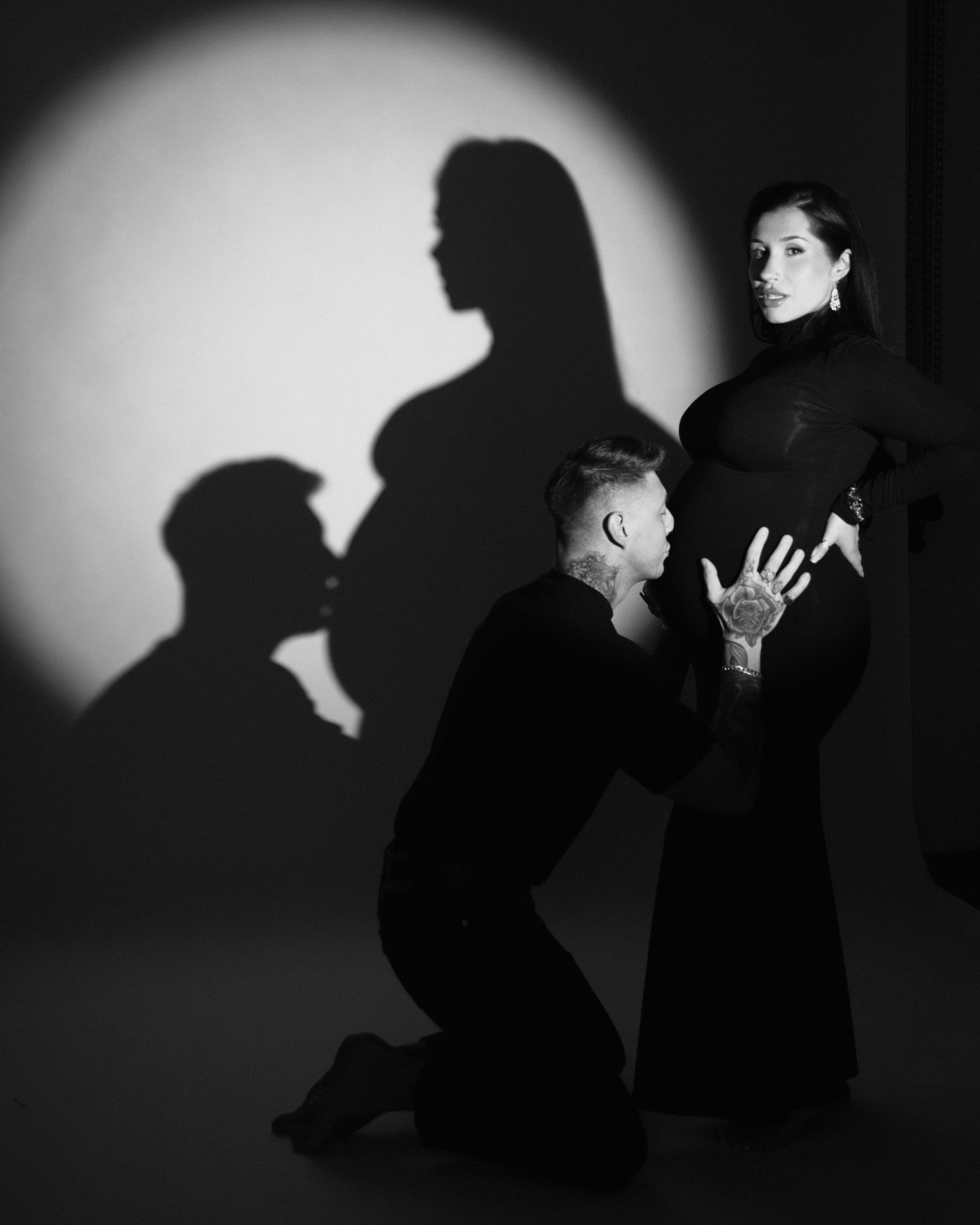 Dramatic black and white silhouette series showing intimate moments between two figures against a stark wall.