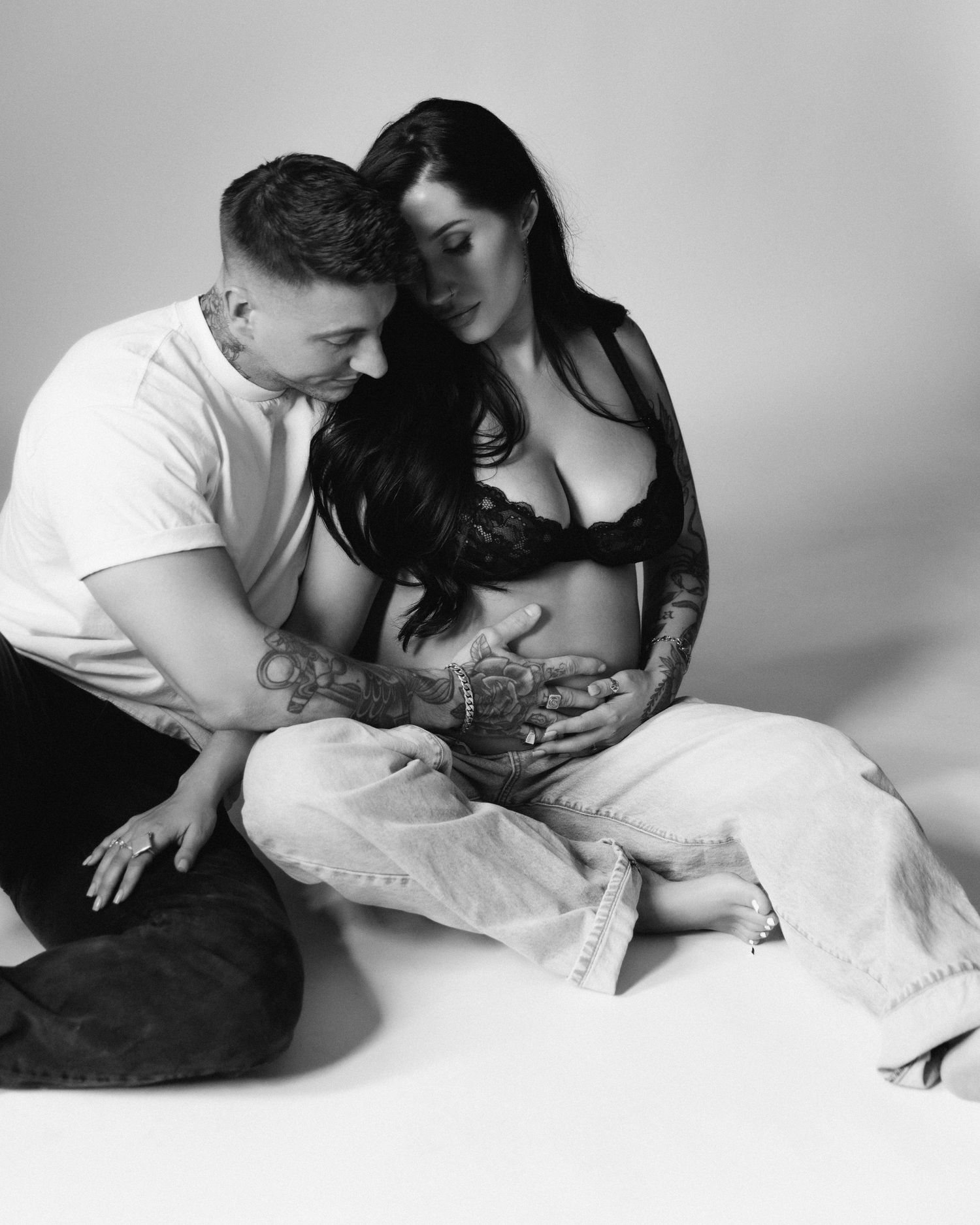 Black and white photo series showing couple in intimate caring poses on bed in monochromatic artistic style.