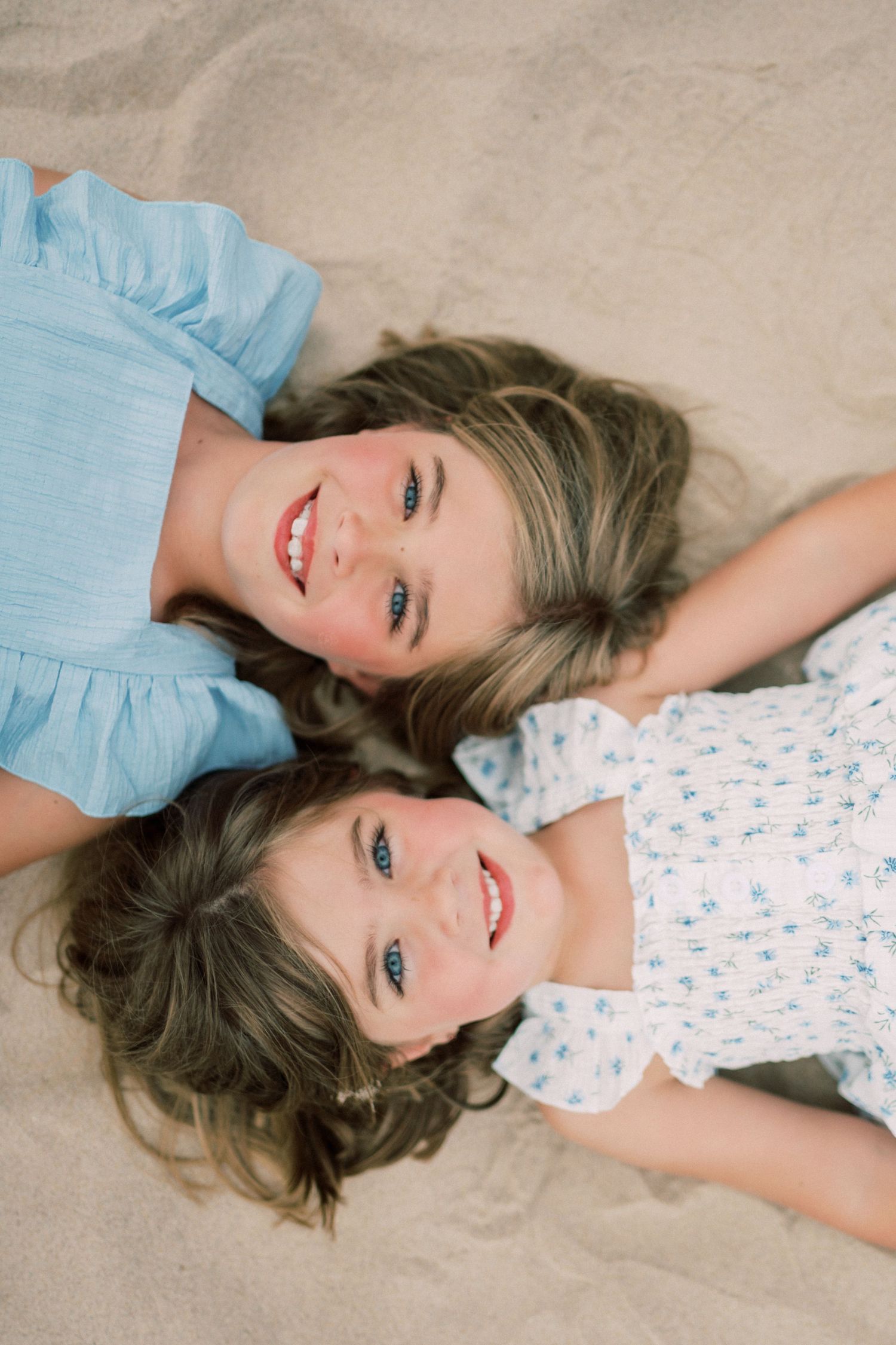 Someone wearing a light blue top lying on a light colored floor in various relaxed poses.