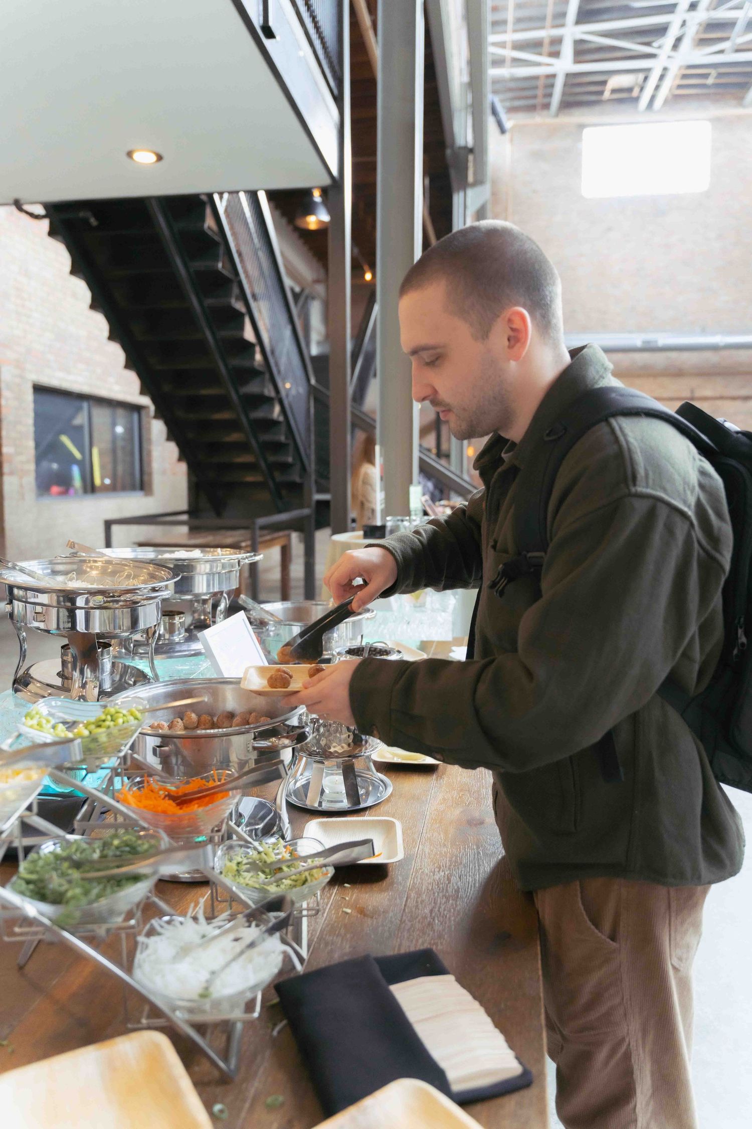 Person serving themselves at an upscale buffet station with multiple dishes and serving utensils. At Fairlie, Chicago