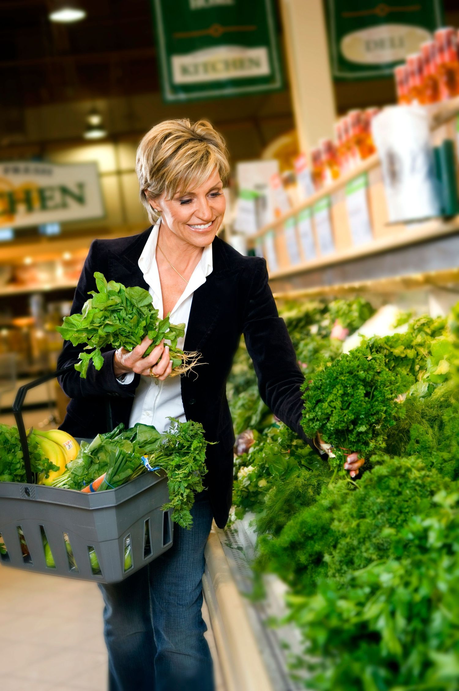 A shopper selecting fresh herbs and produce at a grocery store.