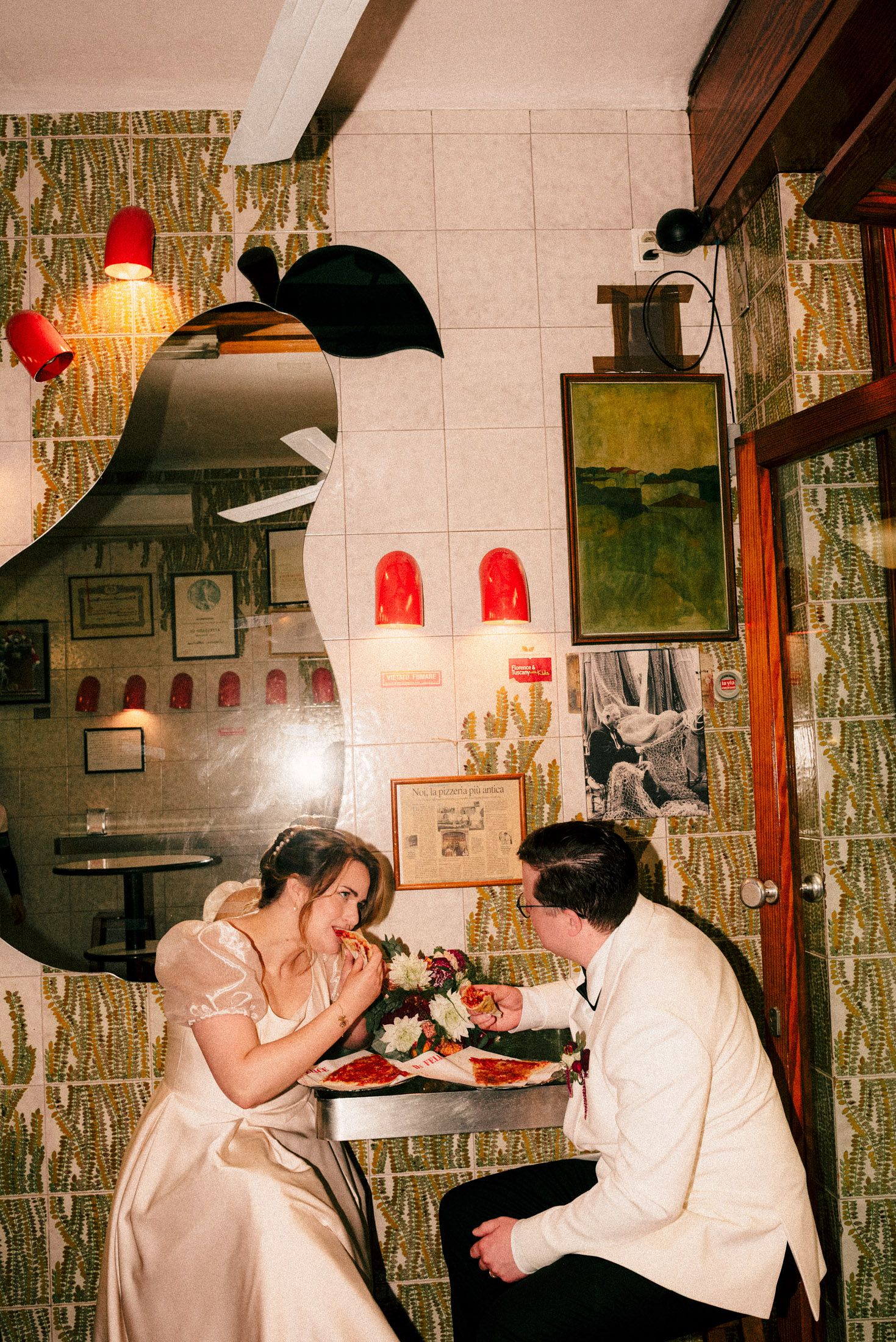 Couple enjoying meal in cozy restaurant with retro decor and wall art.