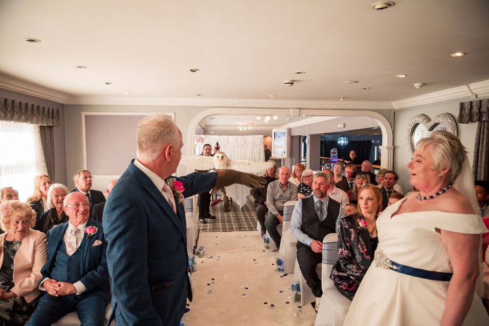 Wedding ceremony captured at luxurious indoor venue with guests looking on as confetti falls during special moment.