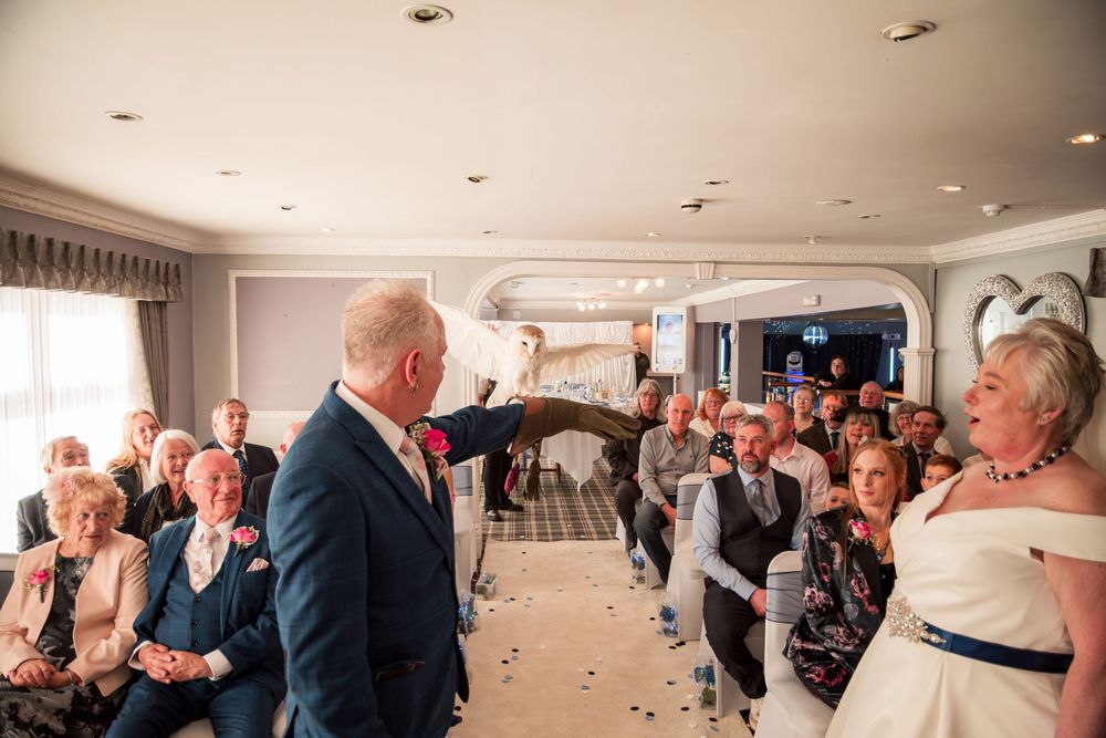 A celebratory moment during an indoor wedding ceremony as guests watch and smile among scattered confetti.