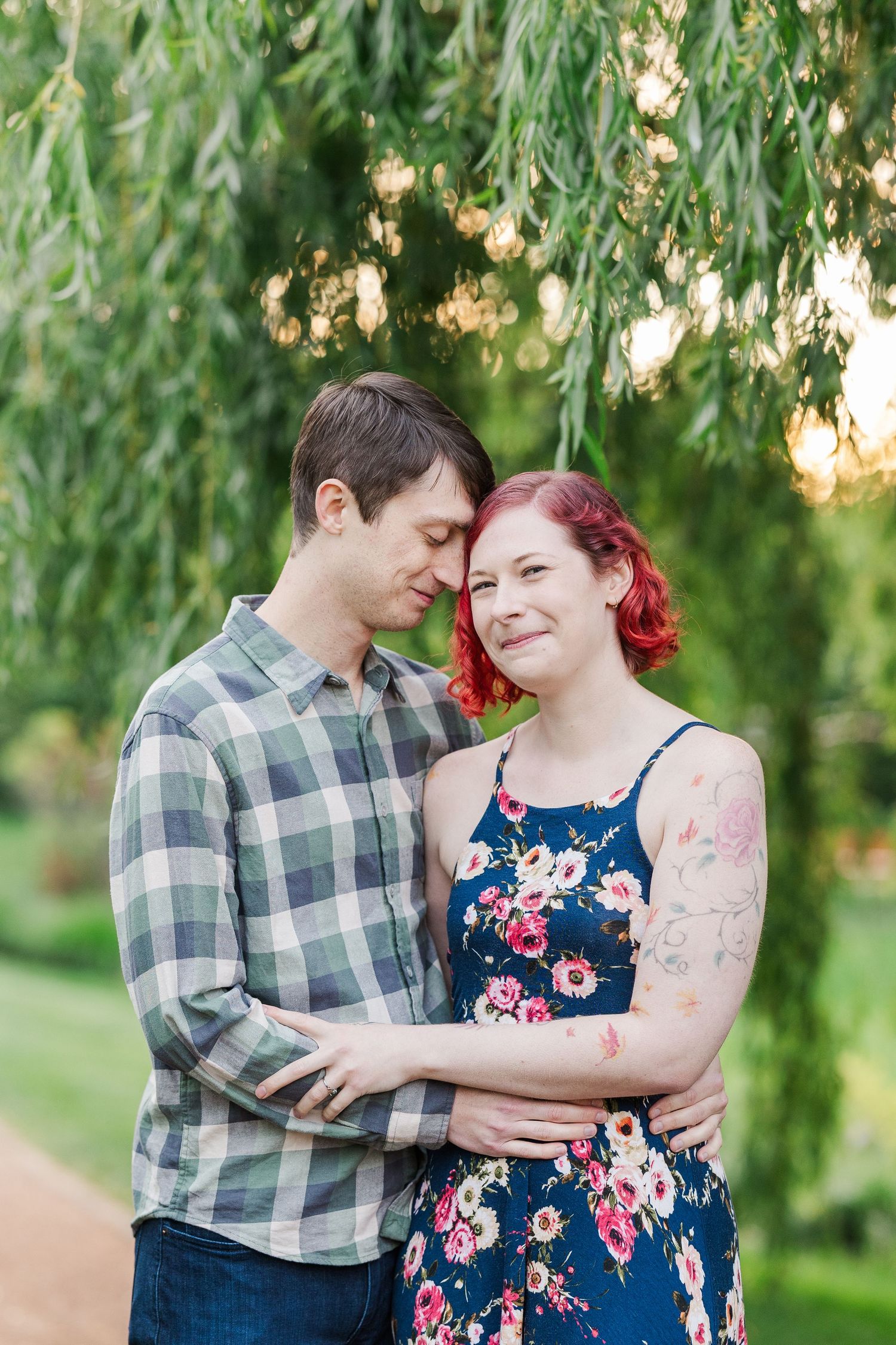 A tender romantic moment captured under a flowering willow tree with soft natural lighting in an outdoor garden setting at Cantigny Park