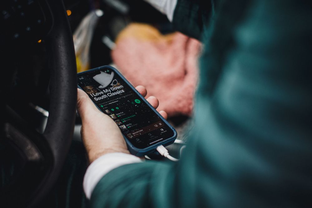 A close-up shot of hands holding a smartphone displaying a dark interface.