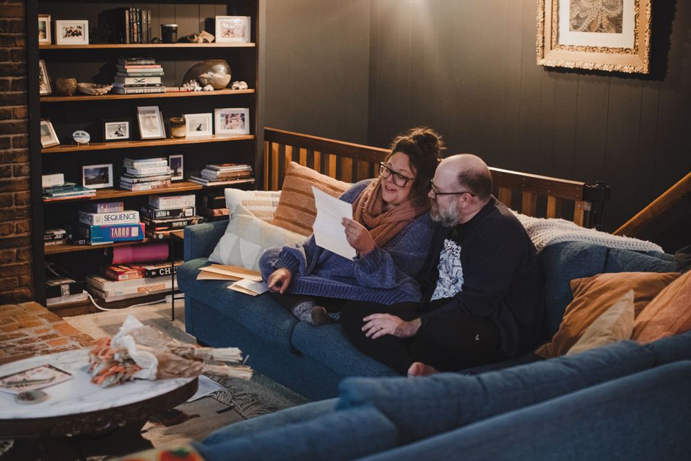 Cozy living area with built-in bookshelves and people relaxing on a blue sofa.