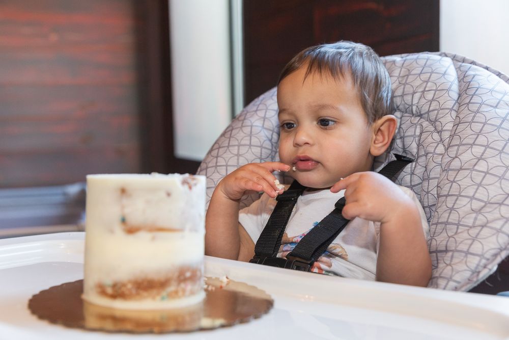 Birthday celebration with cake and high chair setup.