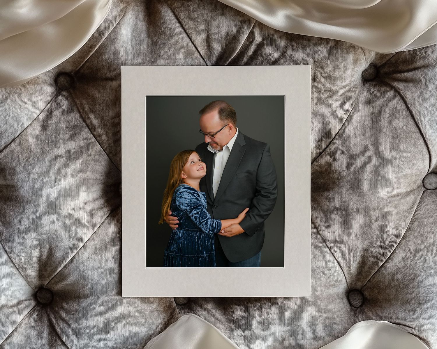 A framed studio portrait displayed on a gray tufted upholstery background from Legacy in His Frame session – heirloom gift for dad Hanford