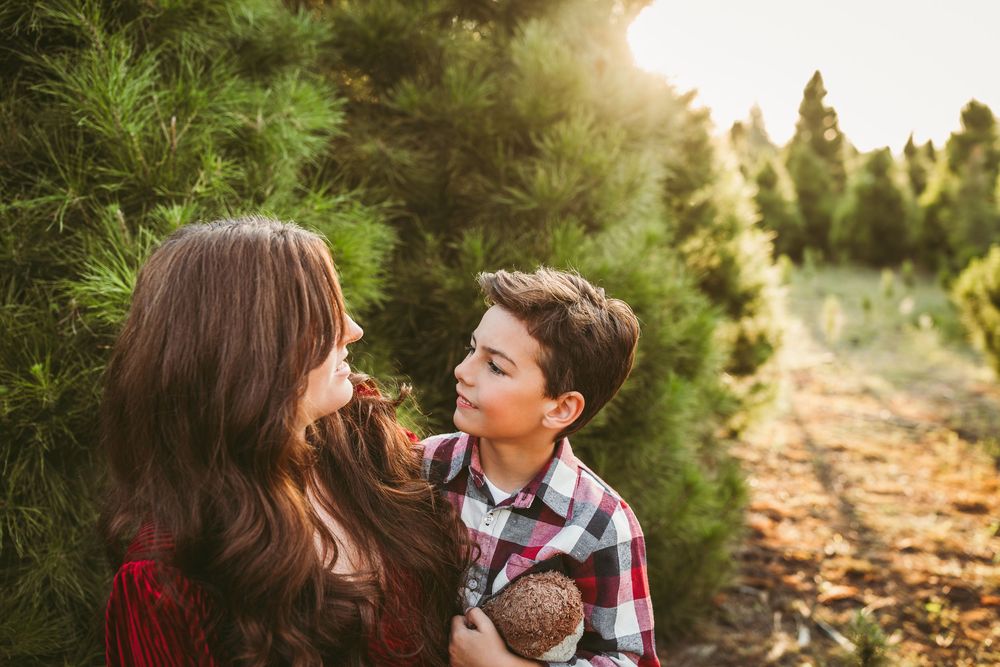 A family photoshoot set in a golden-lit wooded path during sunset, featuring warm autumn colors and natural poses.