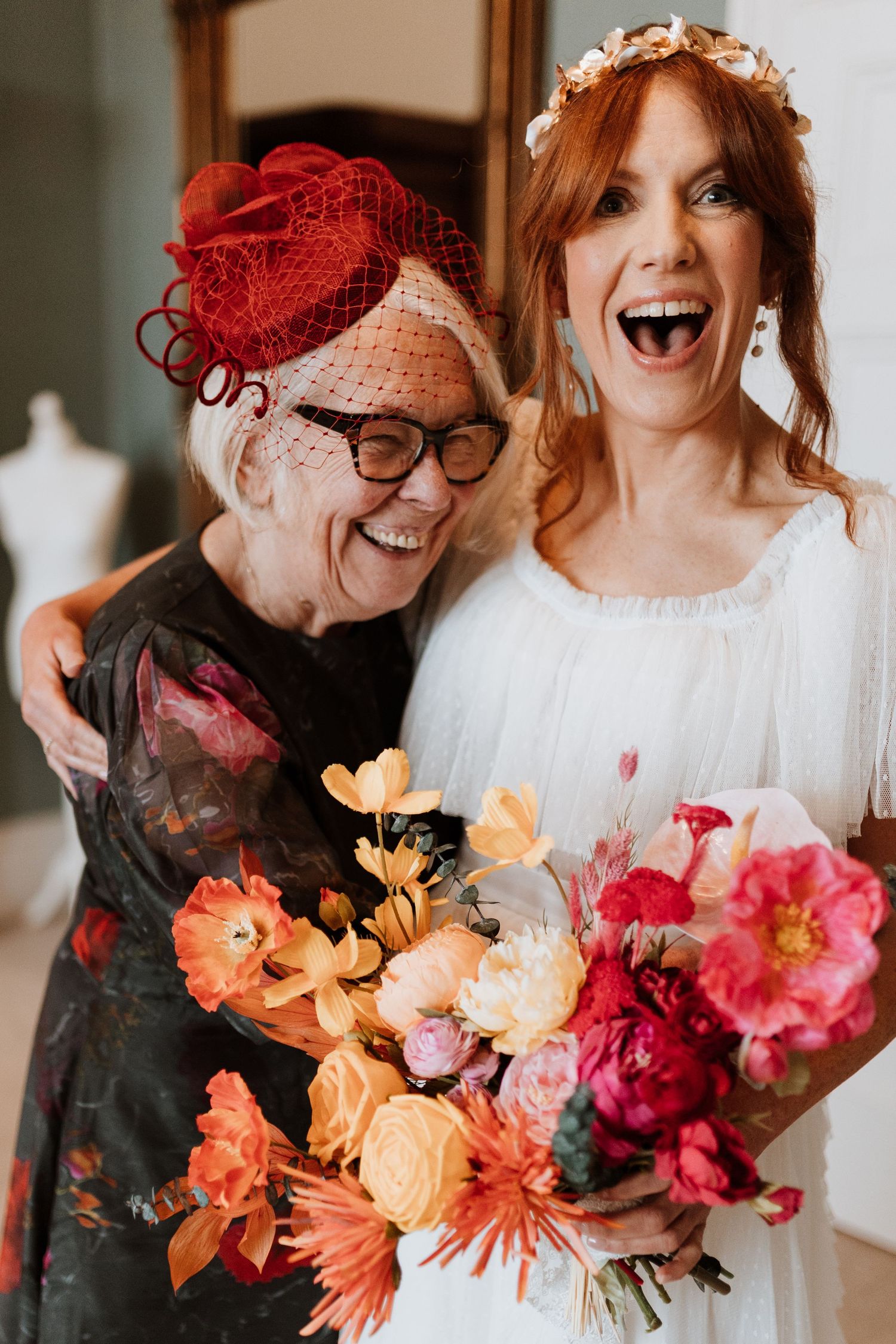 A joyful moment captured with a vibrant bouquet of orange and pink flowers at a wedding celebration at Berwick House.