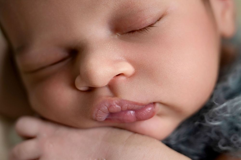 Close-up view of a sleeping baby's face in soft natural lighting showing peaceful expression.