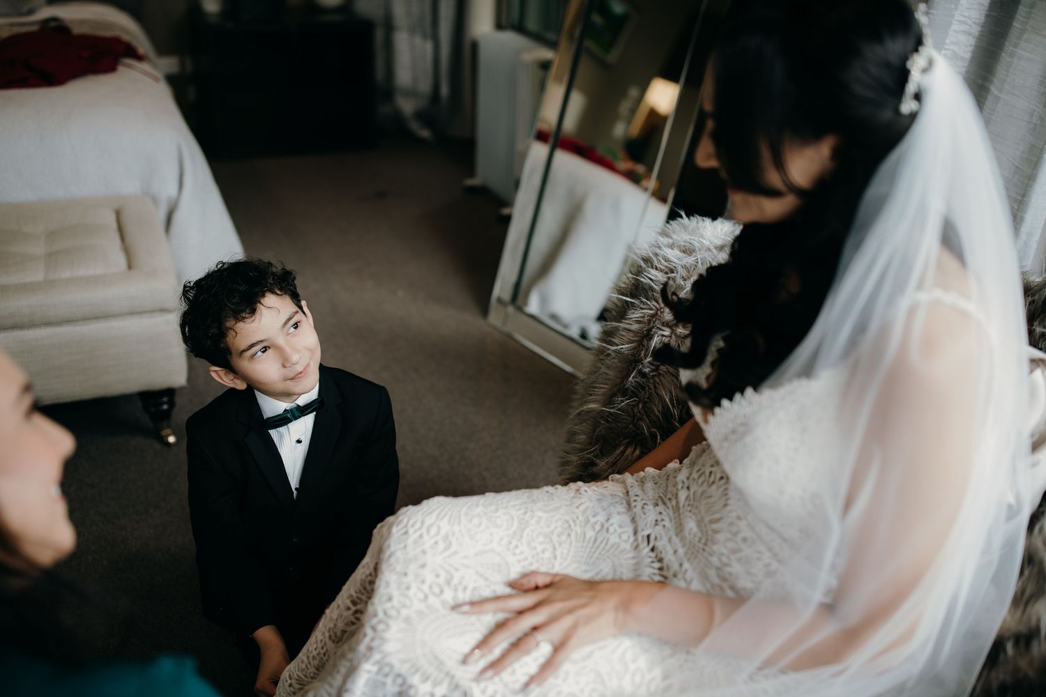 A candid moment captured at a wedding showing tender interaction between the couple with flowing white veil details.