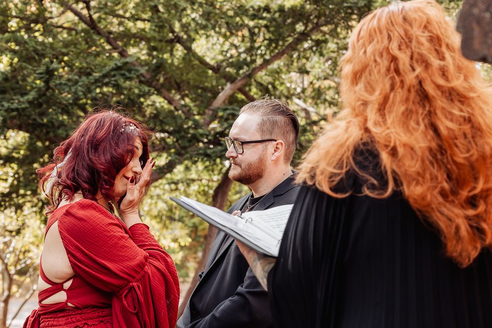 An intimate outdoor wedding ceremony with an officiant reading vows to the couple.