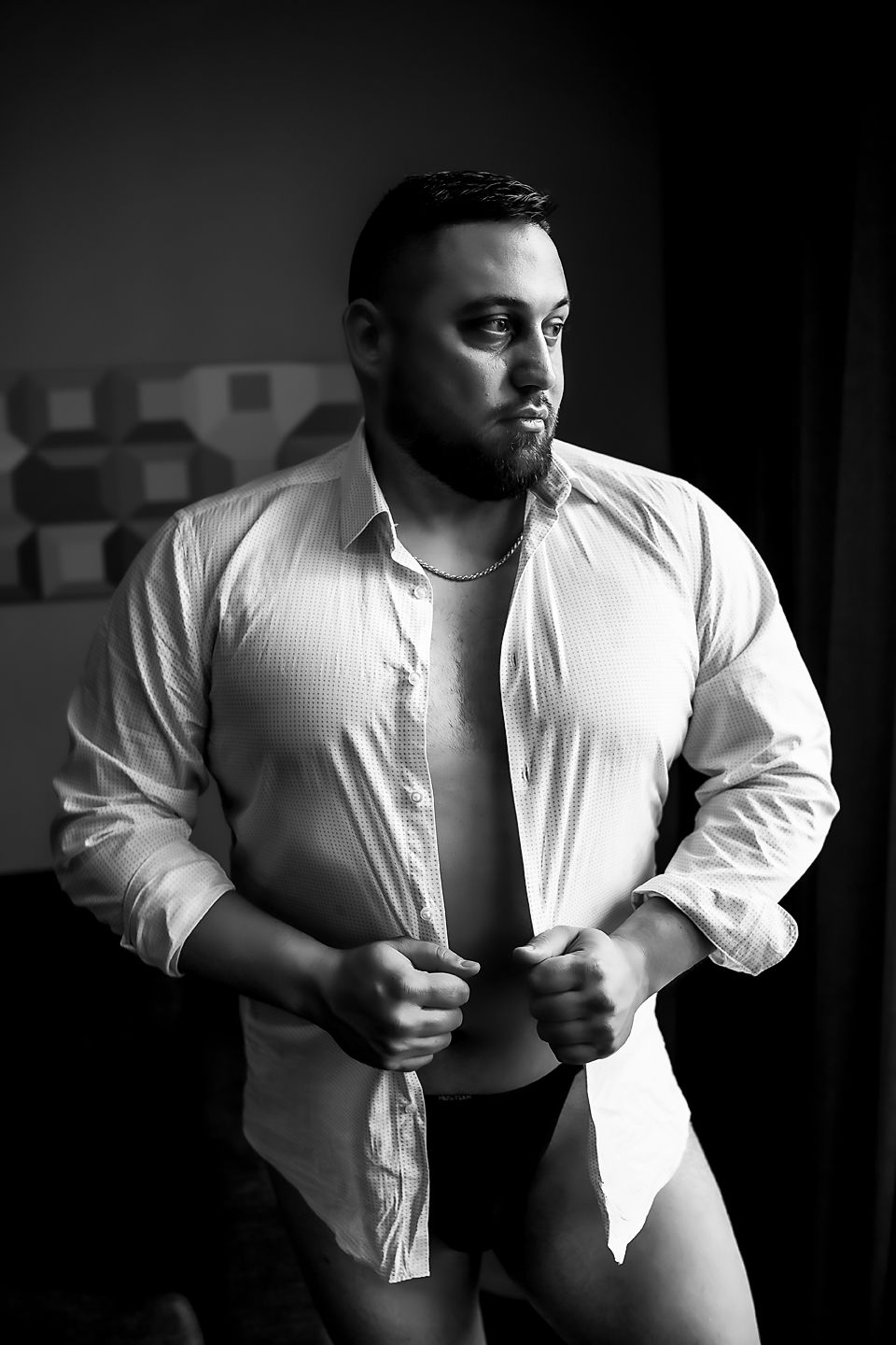 Dramatic black and white series of four images showing upper body and arms in white shirt against dark background.