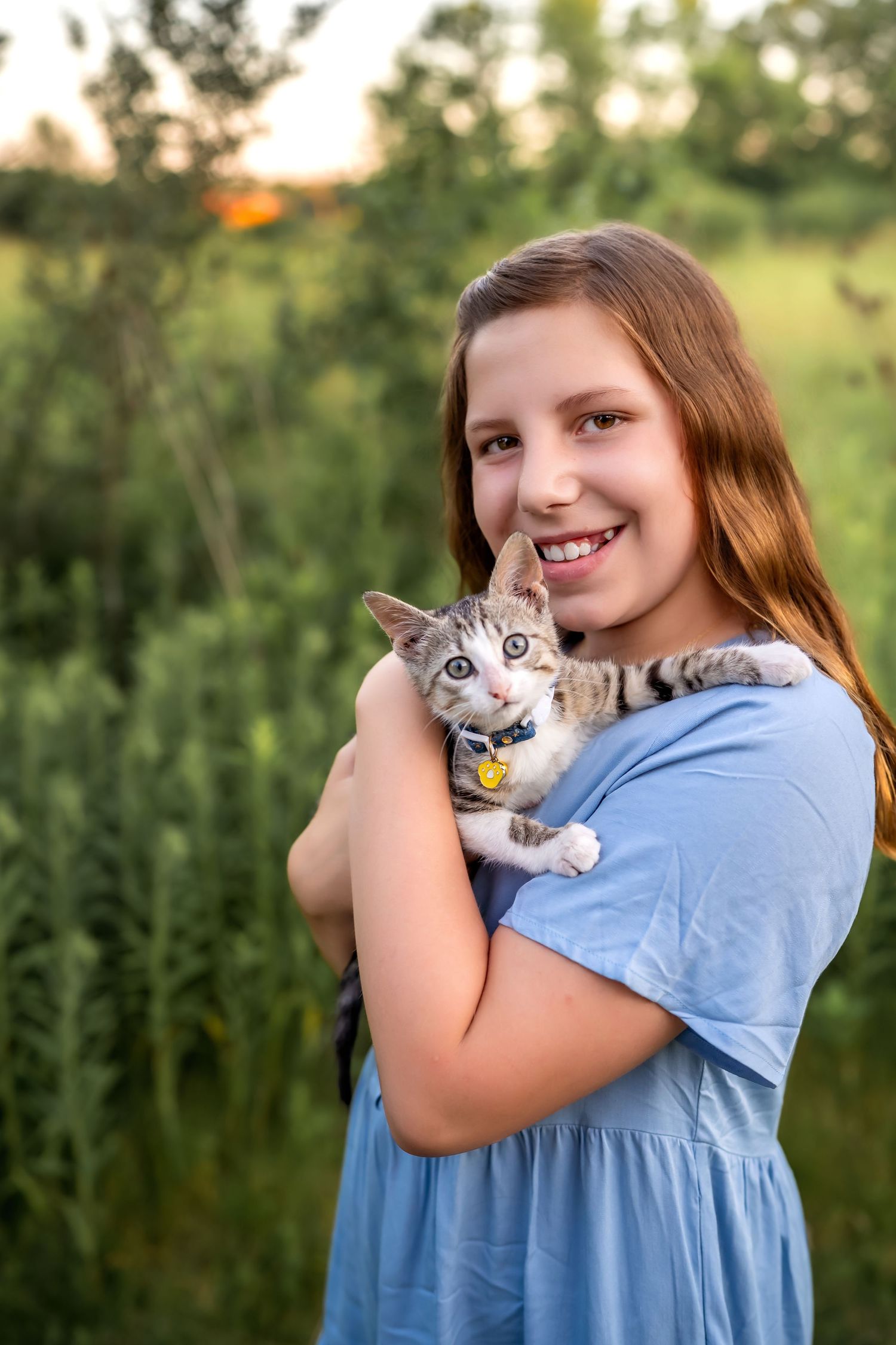A heartwarming series of outdoor portraits showing tender moments between someone in blue holding a small calico cat.